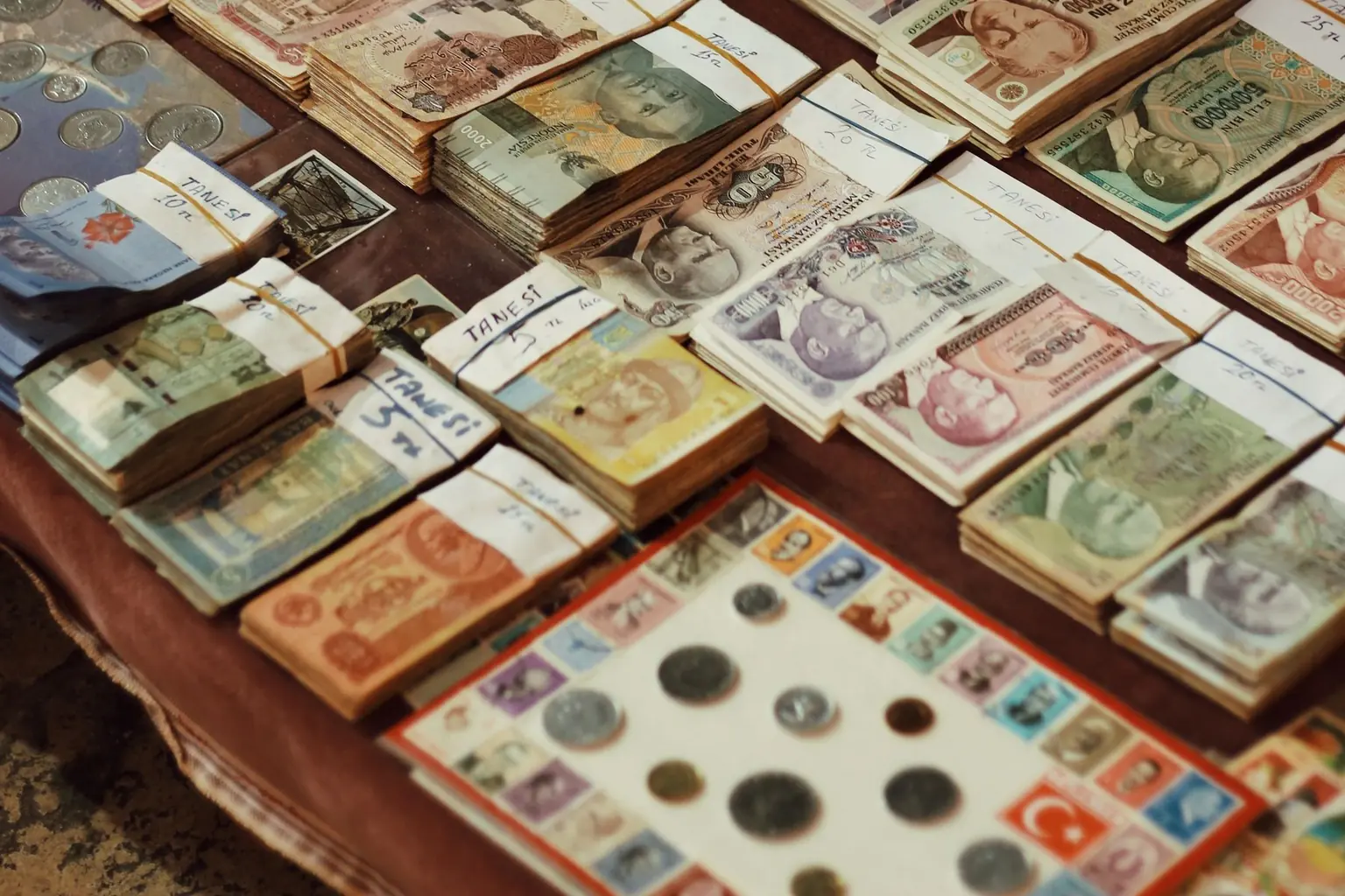 Assorted vintage banknotes arranged by country and denomination on a market table