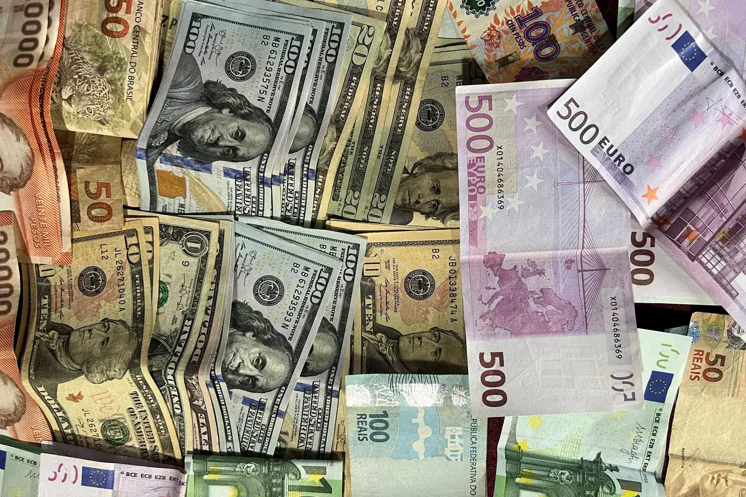 Mixed international banknotes from several countries and currencies arranged together
